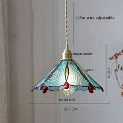 Decorative pendant light with stained glass shade and measurements on a plain background