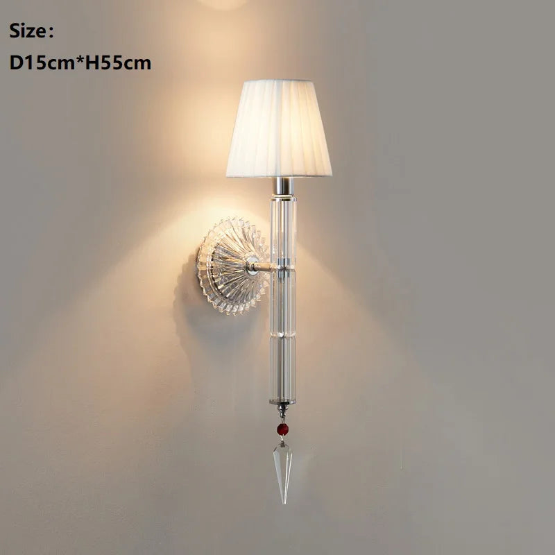 Wall-mounted lamp with decorative crystal design on a plain wall.