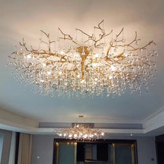 Close-up of the gold branch chandelier structure with numerous hanging clear crystals.