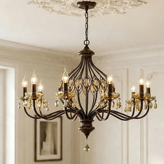 Side view of a multi-arm bronze chandelier adorned with amber crystals, suspended indoors.