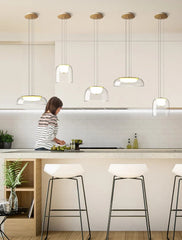 Modern kitchen with pendant lights and a person cooking.
