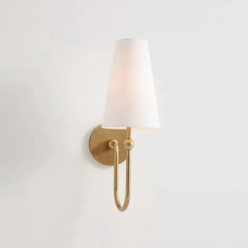 Wall-mounted light fixture with white shade and gold finish on a plain background