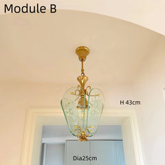 Gold pendant light fixture with green glass shade in a room setting, labeled 'Module B'.