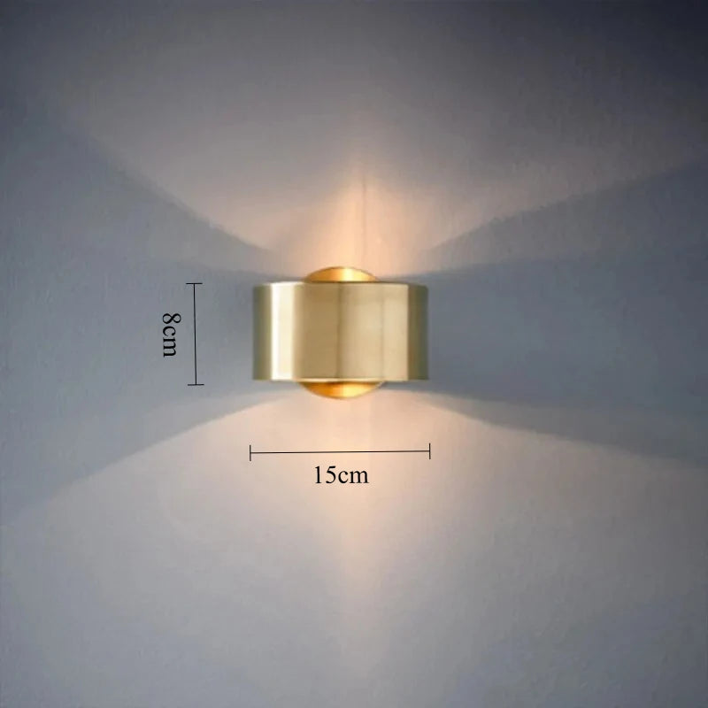 Gold wall light fixture on a gray wall with measurements indicated.