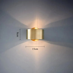 Gold wall light fixture on a gray wall with measurements indicated.