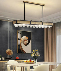 Modern pendant light fixture in a stylish interior setting with a dining table and abstract art.