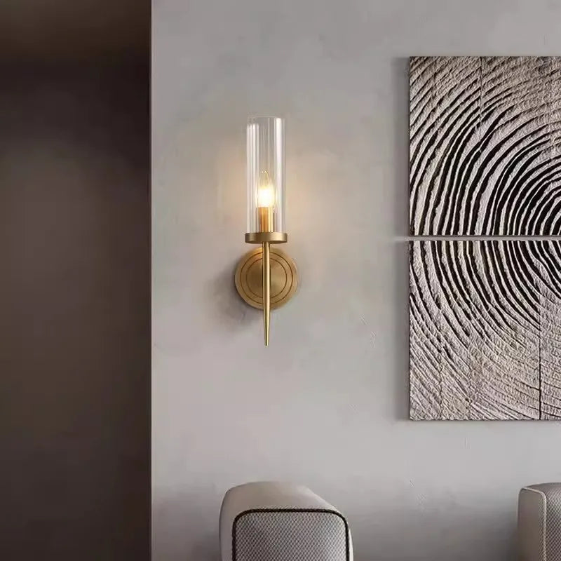Wall sconce with a textured wall art piece on a gray wall.