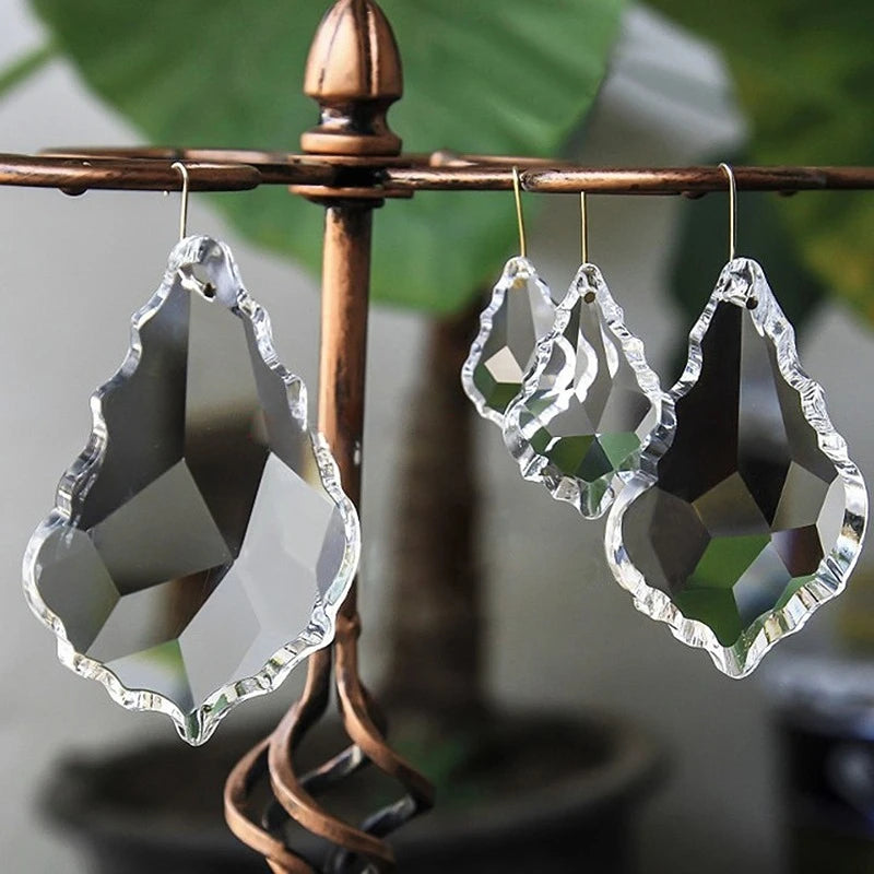 Clear crystal earrings on a decorative stand with a blurred green leafy background