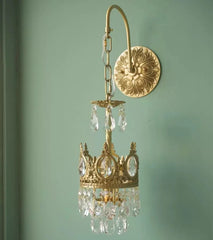 Gold chandelier with crystal accents on a light green wall