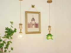 Two hanging pendant lights with glass shades in a room with a framed picture on the wall.