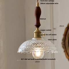 Pendant light fixture with clear glass shade and wooden canopy, labeled with features.