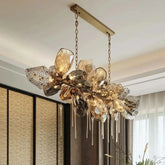 A wide shot of a gold chandelier with cascading faceted crystals hanging from a ceiling.
