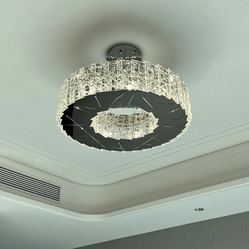 View of a modern spiral crystal flush mount chandelier showing its circular form and the light it casts on the ceiling.