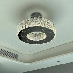 View of a modern spiral crystal flush mount chandelier showing its circular form and the light it casts on the ceiling.