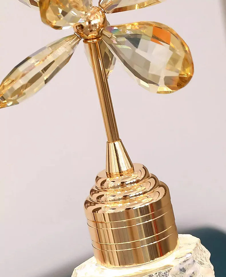 Gold decorative object with crystal-like elements on a light gray background