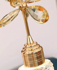 Gold decorative object with crystal-like elements on a light gray background