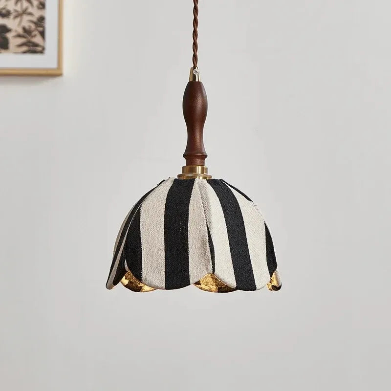 Close-up view of the black and white striped fabric pendant light, highlighting the texture of the fabric and the brass fittings.