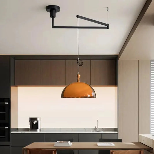 Kitchen island pendant light with an amber glass dome shade and black adjustable arm