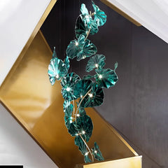 Decorative chandelier with green leaf-like lights hanging against a modern interior background.