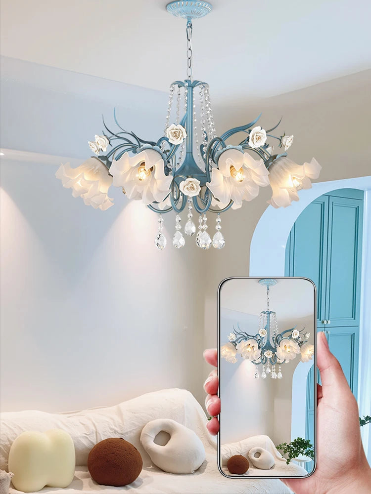Floral chandelier in a room with a phone capturing the view.