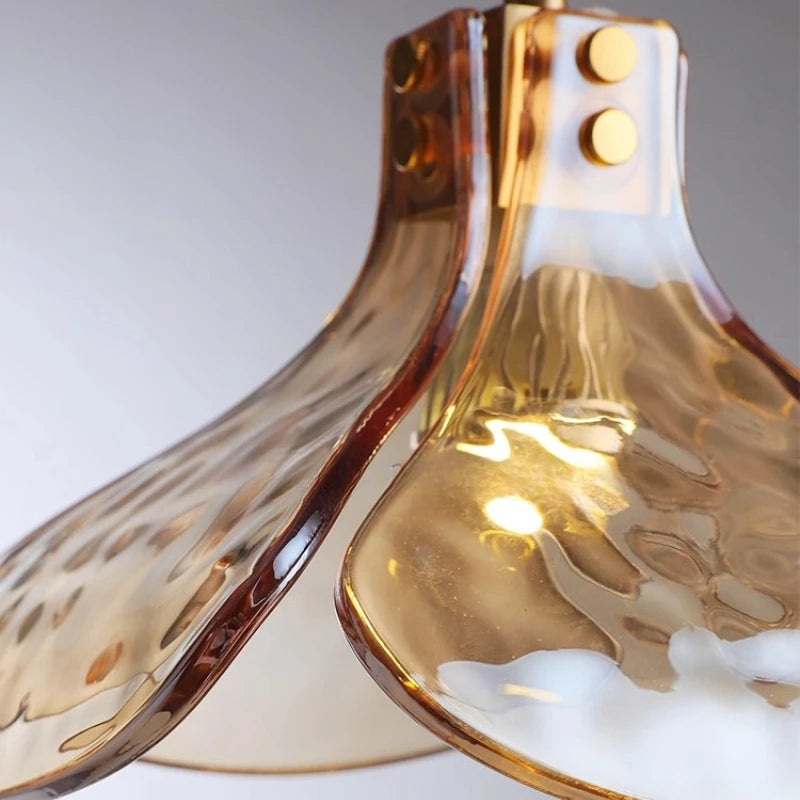 Close-up of two gold-colored glass lampshades on a white background