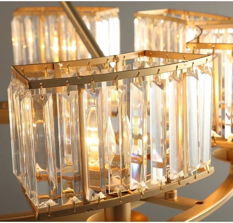 Gold chandelier with crystal-like glass panels on a gray background