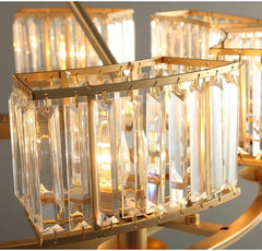 Gold chandelier with crystal-like glass panels on a gray background