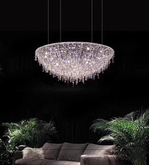 Luxury chandelier hanging above a sofa with plants in the background