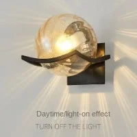 Wall-mounted light fixture with a glass shade on a white background