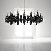 Black globe cluster pendant light against a white wall with a window in the background, showing a reflective surface below.