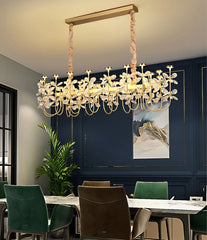 Modern chandelier hanging above a dining table with chairs in a room.