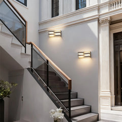 Staircase with modern railings and wall lights in a well-lit interior setting.