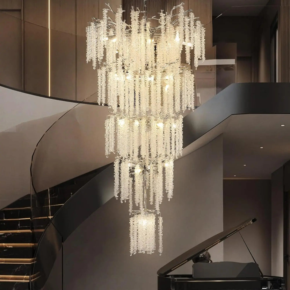 Luxurious chandelier hanging in a modern interior setting with a staircase and piano.