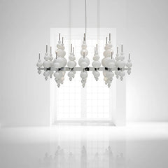 White globe cluster pendant light against a white wall with a window in the background, showing a reflective surface below.