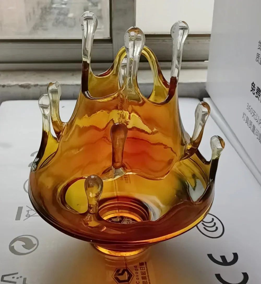Glass crown-shaped object with a gradient of colors on a white surface