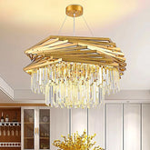 A golden geometric chandelier with cascading crystal prisms hangs from the ceiling in a dining room setting with a wine rack visible.