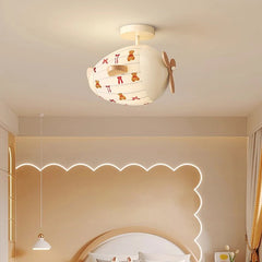 Close-up of the airplane-shaped ceiling light, showing the fabric texture and wooden propeller detail.