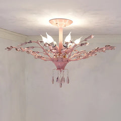 Side view of a pink floral semi-flush ceiling light with crystal accents and decorative light bulbs.