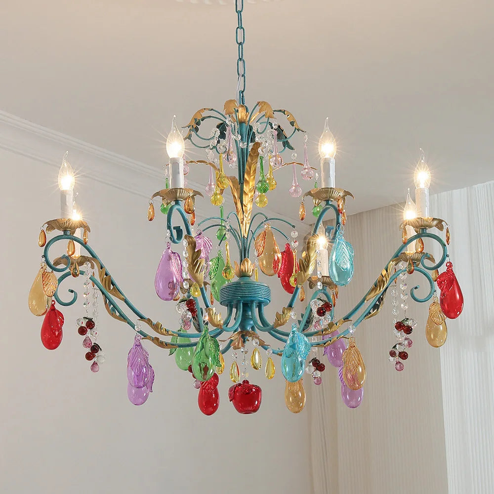 Gold floral fruit crystal chandelier with colorful teardrop accents hanging from a blue chain against a white ceiling.