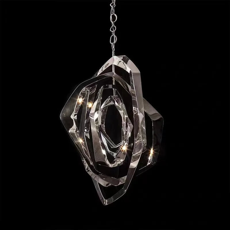 A clear faceted crystal geometric pendant light with internal lighting, set against a black background.