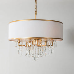 Gold drum shade chandelier with cascading clear crystals against a white background.