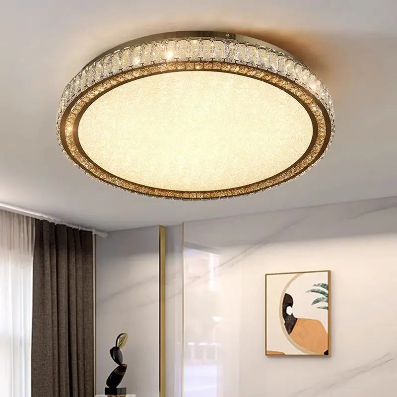 Close-up of a flush mount ceiling light with a gold frame and crystal accents, emitting warm light.