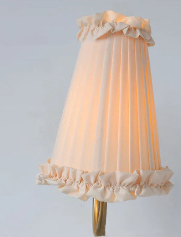 warm ambient wall sconce with tassel-trim shade for bedroom or hallway lighting