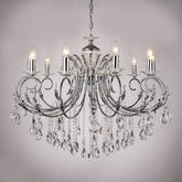 Polished gold candelabra chandelier with cascading crystals and candle-style lights, shown against a light gray background.