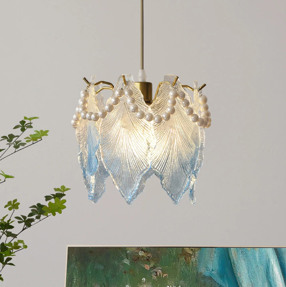 Decorative ceiling light fixture with pearl-like beads and leaf-like design on a plain background.
