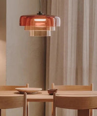 Dining area with wooden table and chairs, featuring a pendant light with a warm glow.