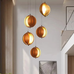 Modern pendant lights hanging in a room with neutral walls and abstract art.