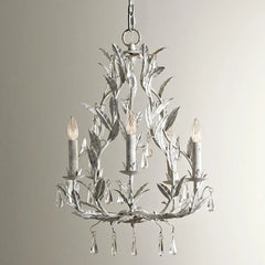 Light grey wrought iron leaf chandelier with clear teardrop crystals hanging from candle-style lights, against a white background.