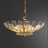 Gold leaf floral chandelier with clear glass petals hanging from a dark background.
