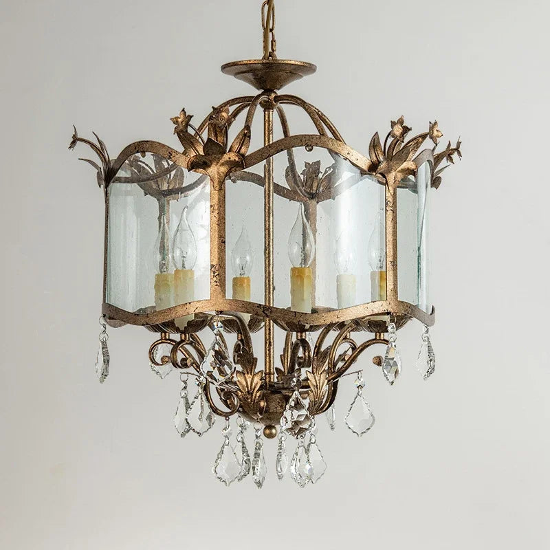 Front view of a gold crystal chandelier with multiple light sources and ornate detailing.